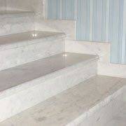 На фото показан фрагмент лестницы - подступенка, калошницы и ступени которой выполнены из белого мрамора.