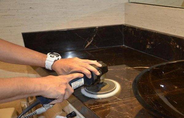 Работа по обработке мрамора с помощью шлифовальной машинки.